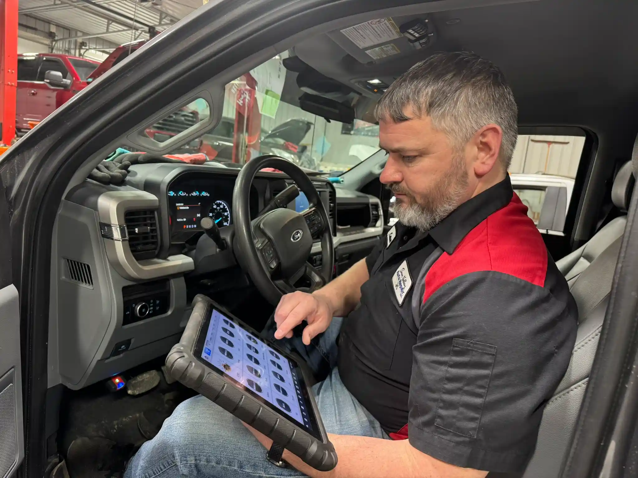Technician performing vehicle diagnostics using a tablet